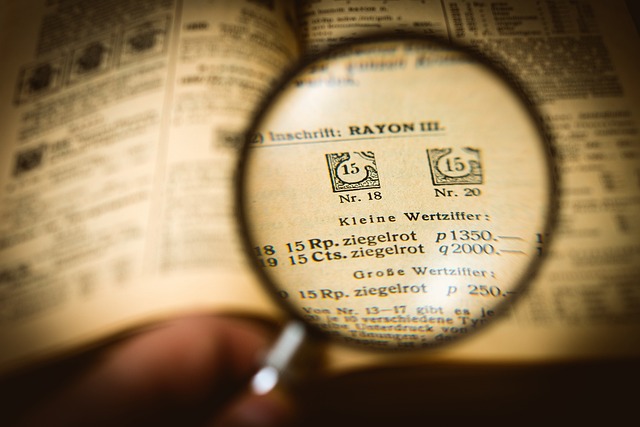 A magnifying glass is held over a document showing text and figures up close.