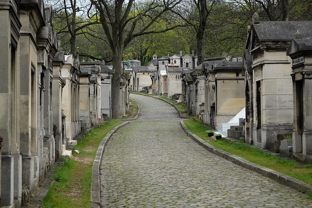 View of walking through a graveyard with above-ground mausoleums.