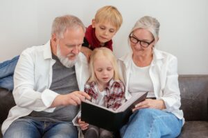 Grandparents on couch with grandchildren, reading to them