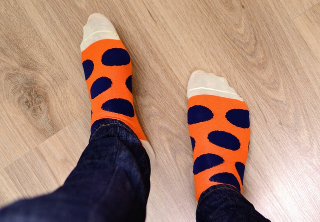 Person wearing matching orange socks with big black dots and white toes.