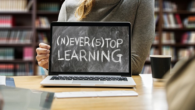 Laptop is open with "Never Stop Learning" shown on screen.