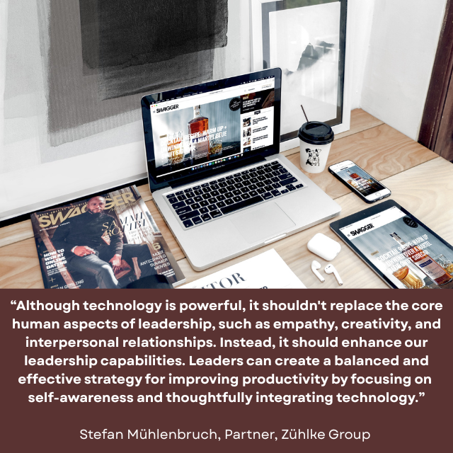 Top of desk holding a laptop, mobile phone, digital tablet, wireless earbuds, a drink, and a few magazines. There is a monitor on the wall. Caption reads: “Although technology is powerful, it shouldn't replace the core human aspects of leadership, such as empathy, creativity, and interpersonal relationships. Instead, it should enhance our leadership capabilities. Leaders can create a balanced and effective strategy for improving productivity by focusing on self-awareness and thoughtfully integrating technology.” -Stefan Mühlenbruch, Partner, Zühlke Group 