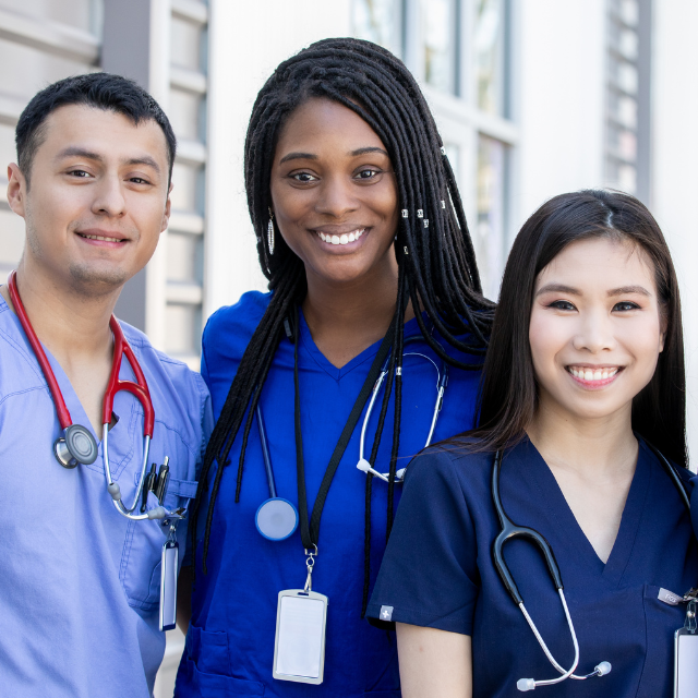 Several smiling people in blue scrubs.