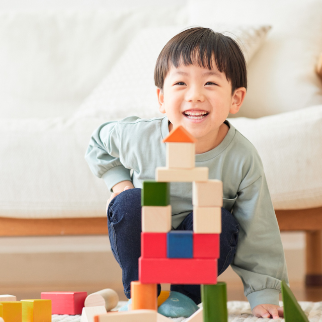 Smiling child playing with blocks.
