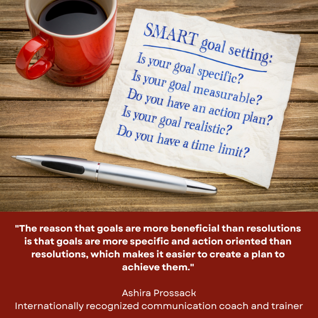Coffee mug and pen on a wooden table, along with a note about SMART goal setting. Caption reads: "The reason that goals are more beneficial than resolutions is that goals are more specific and action oriented than resolutions, which makes it easier to create a plan to achieve them." - Ashira Prossack, internationally recognized communication coach and trainer 