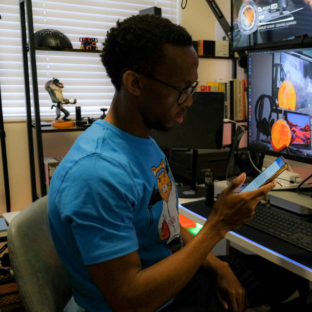 Person working on computer and mobile phone.