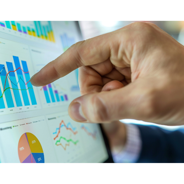 A hand points at several graphs and charts on a computer screen.