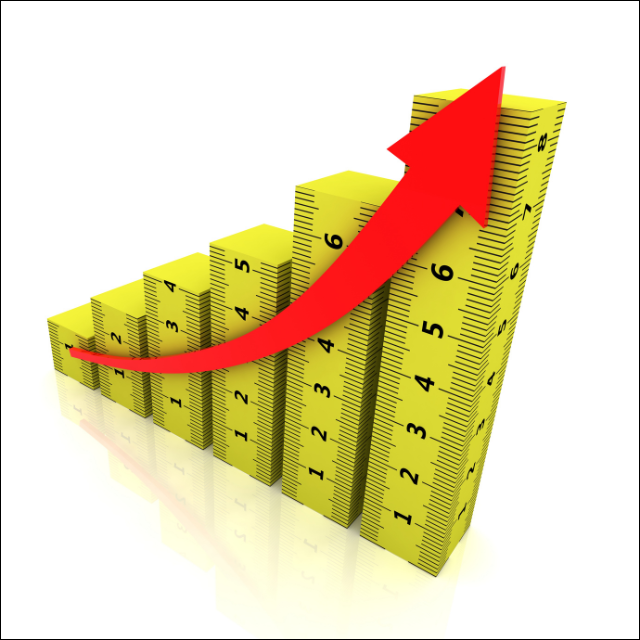 Illustration of stacked yellow measuring tapes arranged as ascending bar-chart columns, with a large red upward arrow sweeping across them to symbolize growth, improvement, increasing performance, or measurable progress.