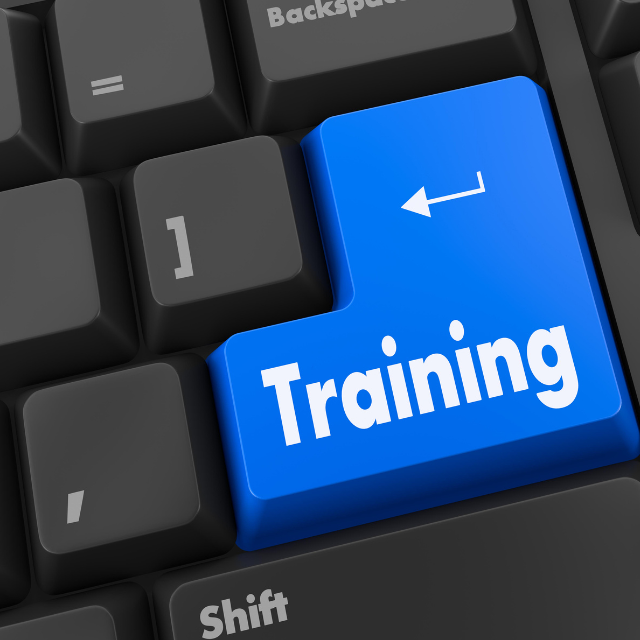 Computer keyboard with a prominent blue “Training” key, symbolizing employee learning, workforce development, and professional training programs.